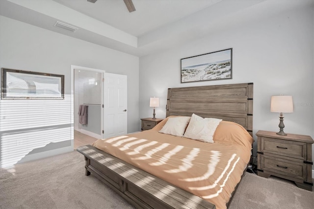 bedroom featuring light carpet, visible vents, ensuite bathroom, and a ceiling fan