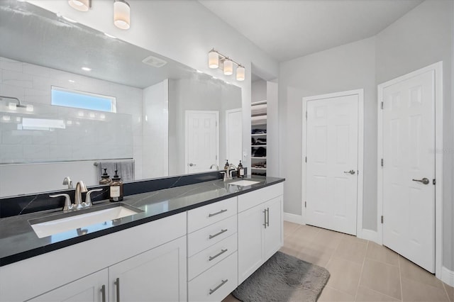 bathroom featuring a sink, a closet, double vanity, and a walk in shower