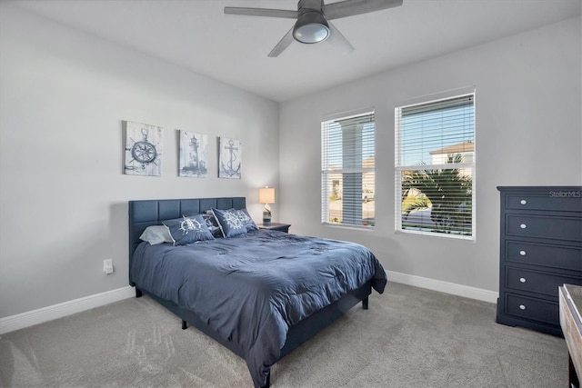 bedroom featuring baseboards, light colored carpet, and ceiling fan