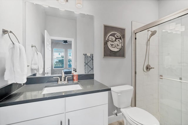 bathroom featuring vanity, a shower stall, and toilet