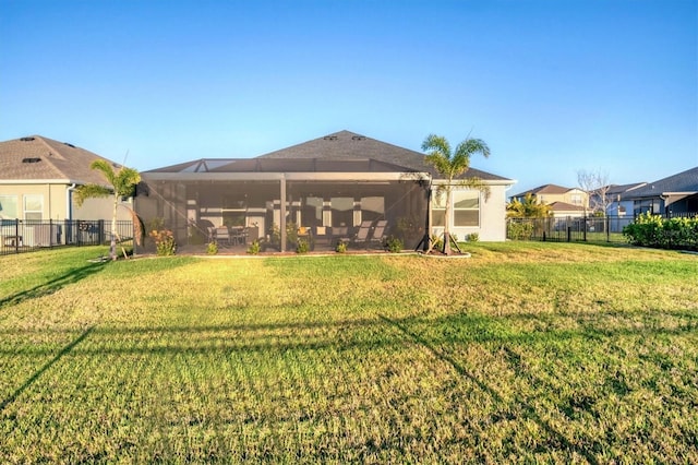 rear view of property with a lanai, a yard, fence private yard, and stucco siding