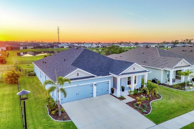 view of front of home with stucco siding, driveway, a residential view, roof with shingles, and a front yard