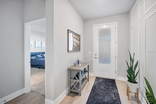 foyer featuring baseboards and light wood-type flooring