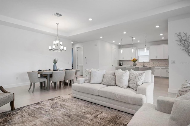 living area with visible vents, baseboards, light tile patterned floors, recessed lighting, and a raised ceiling