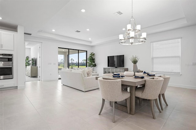 dining space featuring visible vents, a tray ceiling, recessed lighting, an inviting chandelier, and baseboards