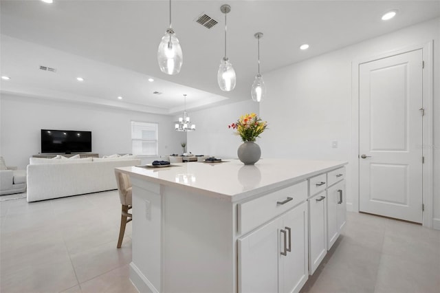 kitchen featuring visible vents, a kitchen island, recessed lighting, white cabinets, and light countertops