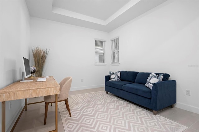 home office featuring baseboards and a tray ceiling