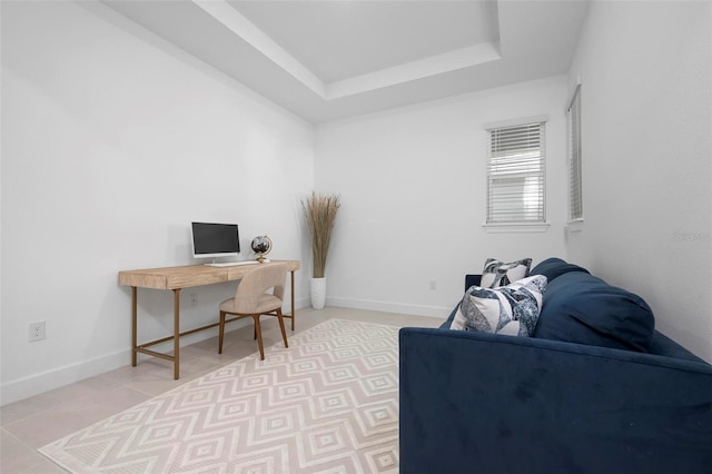 office featuring baseboards, a raised ceiling, and light tile patterned flooring