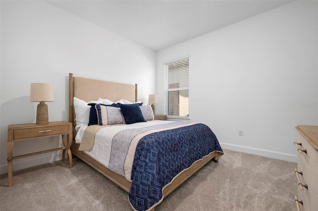 carpeted bedroom featuring baseboards and vaulted ceiling