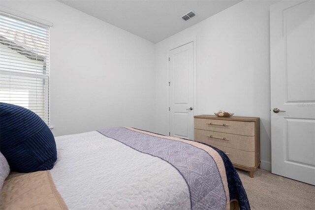 carpeted bedroom featuring visible vents