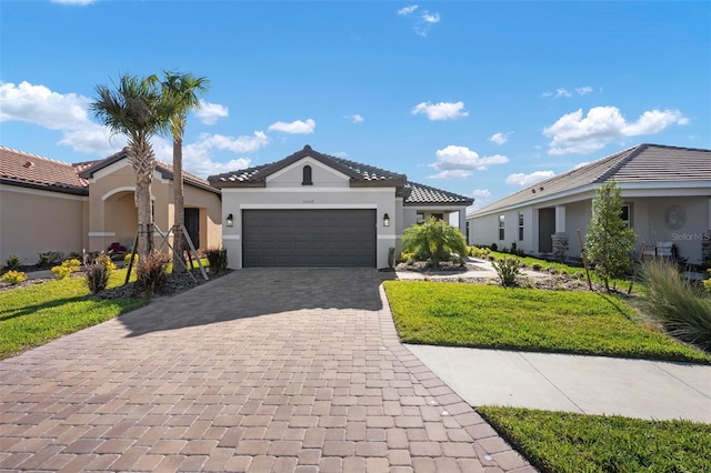 single story home featuring a tiled roof, stucco siding, an attached garage, and decorative driveway