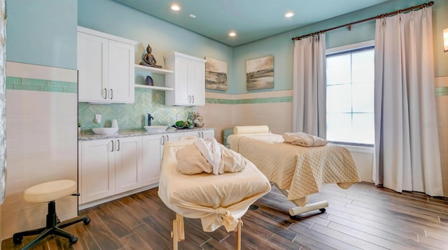 bedroom with dark wood finished floors, recessed lighting, and a sink