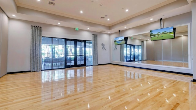 workout area with recessed lighting, a tray ceiling, visible vents, and ornamental molding