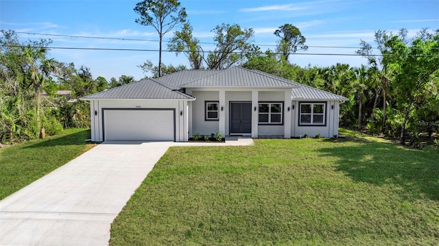 view of front facade with a garage, driveway, metal roof, and a front yard