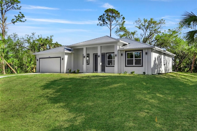 view of front of property with an attached garage, metal roof, driveway, and a front yard