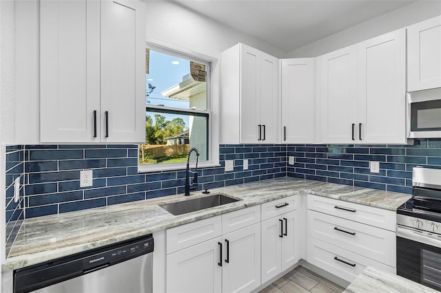 kitchen with a sink, appliances with stainless steel finishes, and white cabinets