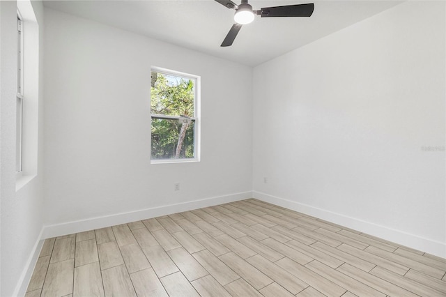 spare room with ceiling fan, baseboards, and light wood-type flooring