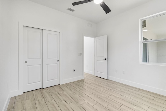 unfurnished bedroom with a closet, visible vents, ceiling fan, and baseboards