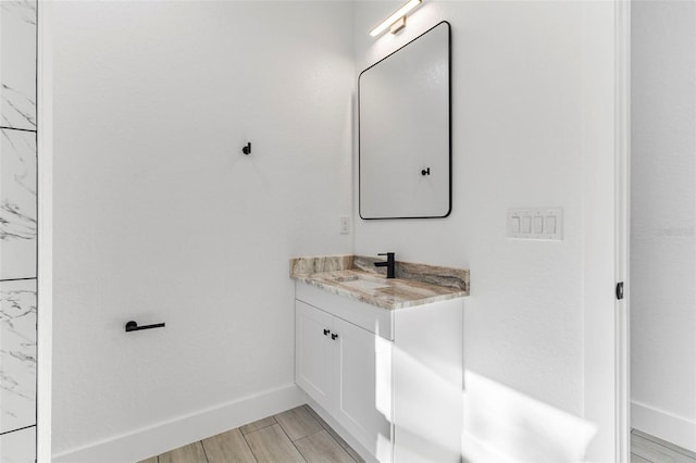 bathroom with baseboards, wood tiled floor, and vanity