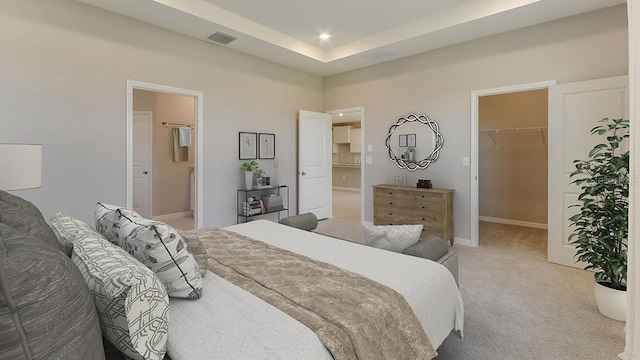 bedroom featuring visible vents, baseboards, recessed lighting, a walk in closet, and light colored carpet