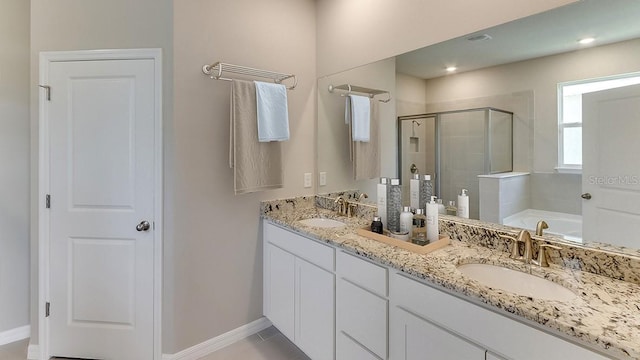 bathroom with double vanity, a stall shower, a garden tub, and a sink