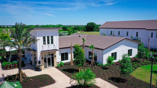 exterior space with board and batten siding, a patio, metal roof, driveway, and a standing seam roof