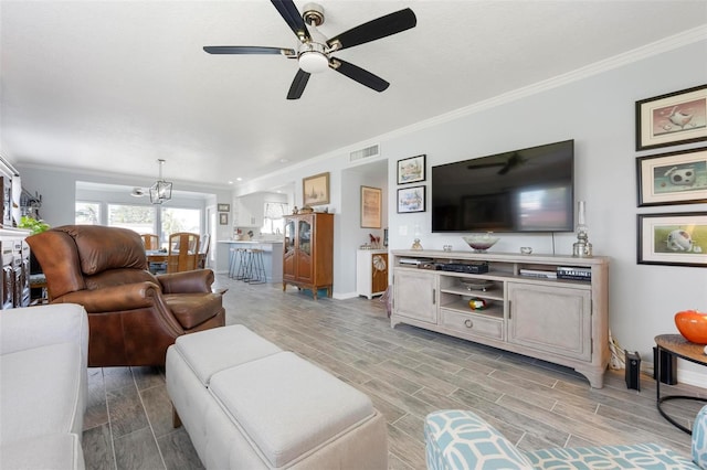 living room with visible vents, baseboards, wood tiled floor, and ceiling fan with notable chandelier