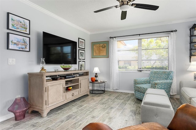 living area with crown molding, a ceiling fan, baseboards, and light wood finished floors