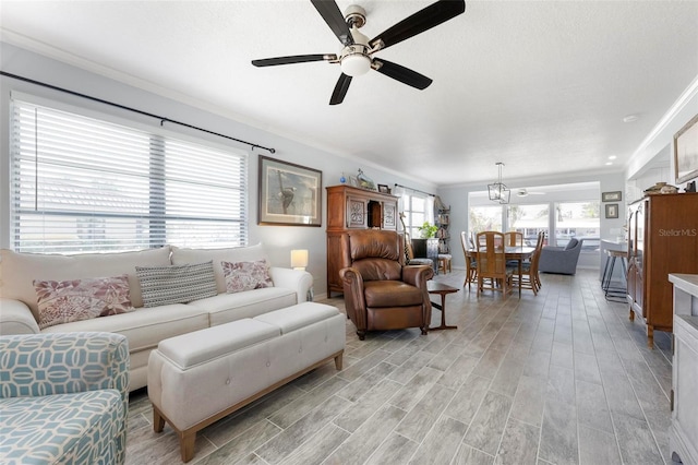 living area featuring a ceiling fan, light wood-style floors, and ornamental molding