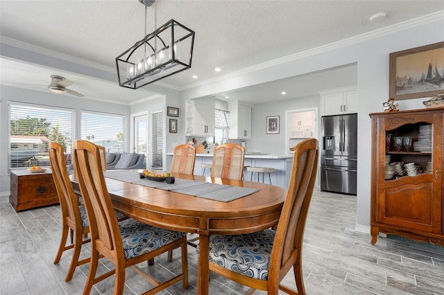 dining space with crown molding, light wood-type flooring, and a ceiling fan