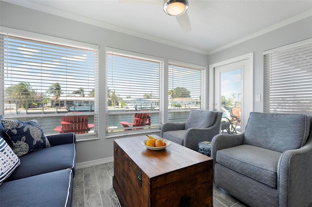 living area featuring baseboards, crown molding, ceiling fan, and wood tiled floor