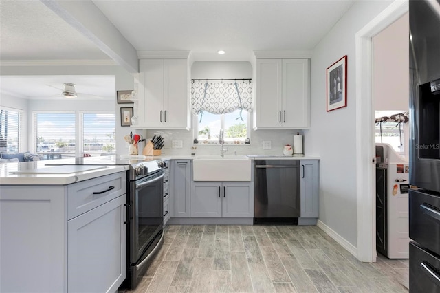 kitchen featuring a sink, a peninsula, light countertops, and stainless steel appliances