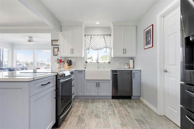 kitchen featuring wood finish floors, appliances with stainless steel finishes, light countertops, and a peninsula