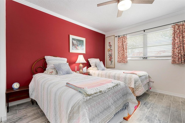 bedroom with ornamental molding, a ceiling fan, a textured ceiling, wood finished floors, and baseboards