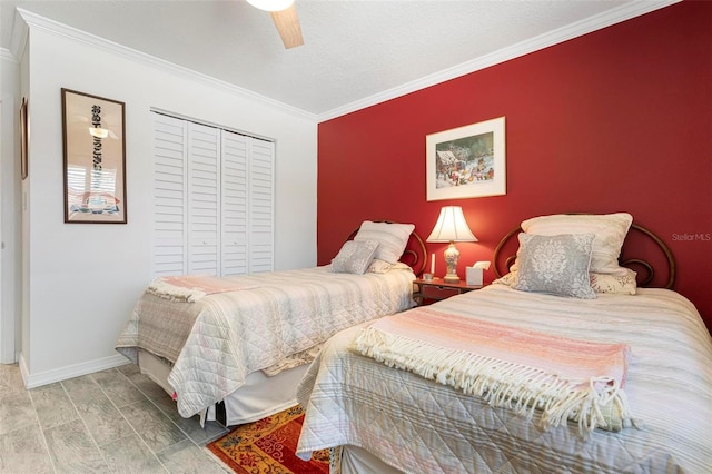 bedroom with wood finish floors, a closet, ornamental molding, and an accent wall