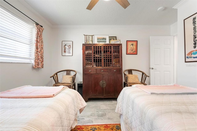 bedroom featuring ceiling fan, a textured ceiling, and ornamental molding