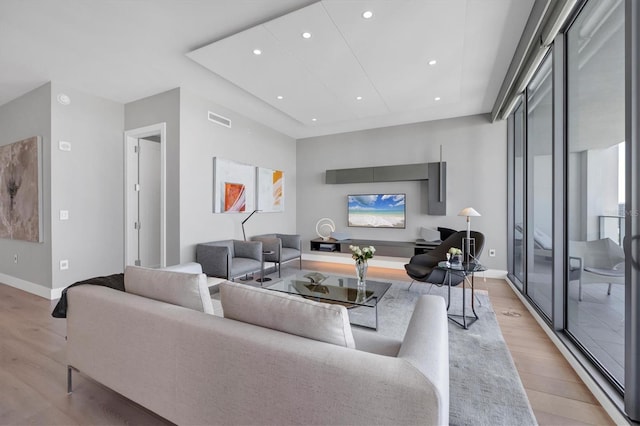 living area featuring recessed lighting, visible vents, baseboards, and light wood-style flooring