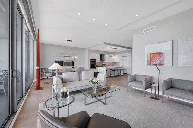 living area with visible vents, recessed lighting, and light wood-style floors