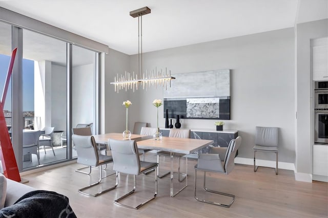 dining area with baseboards and wood finished floors