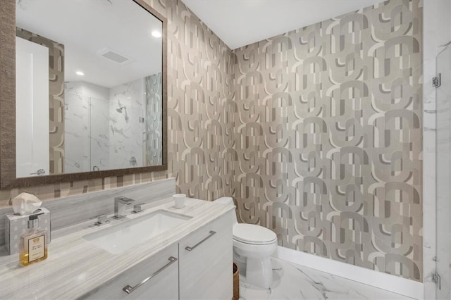 full bathroom with visible vents, toilet, marble finish floor, a marble finish shower, and vanity