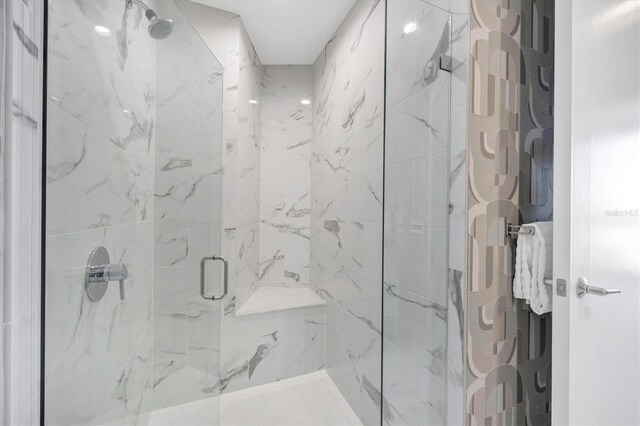 bathroom featuring a marble finish shower