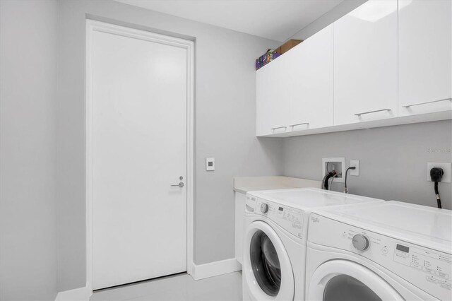 laundry area with cabinet space, baseboards, and washer and clothes dryer