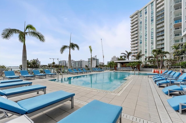 pool with a city view, a patio, and fence