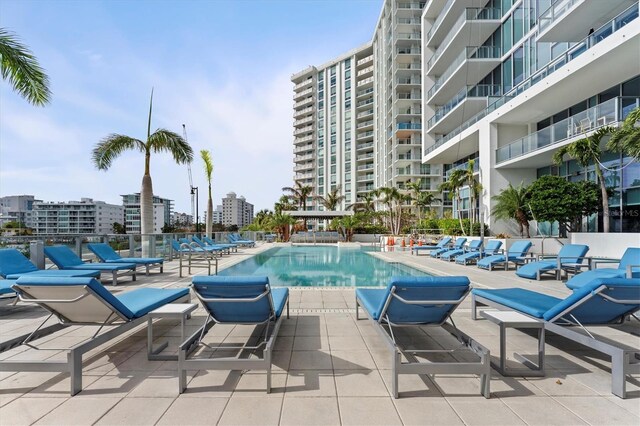 community pool with a city view and a patio