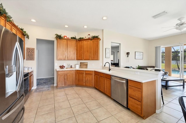 kitchen with visible vents, a sink, stainless steel appliances, a peninsula, and light countertops