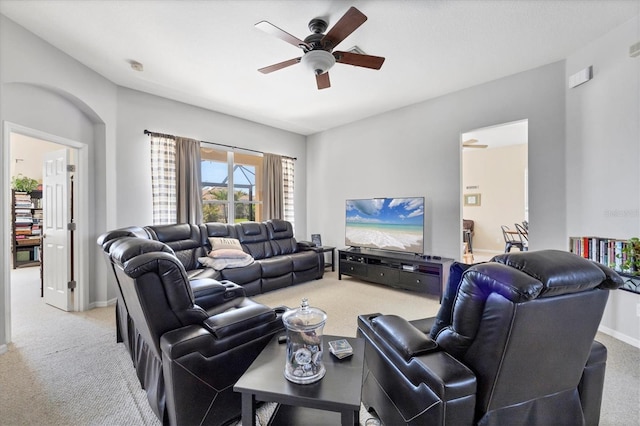 carpeted living area featuring baseboards and a ceiling fan