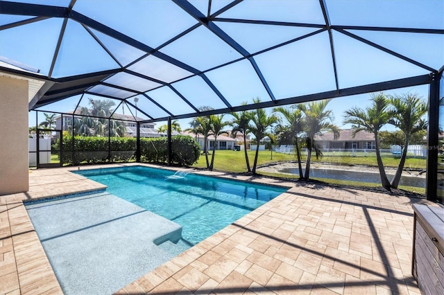 pool featuring a lanai, a patio area, and a yard