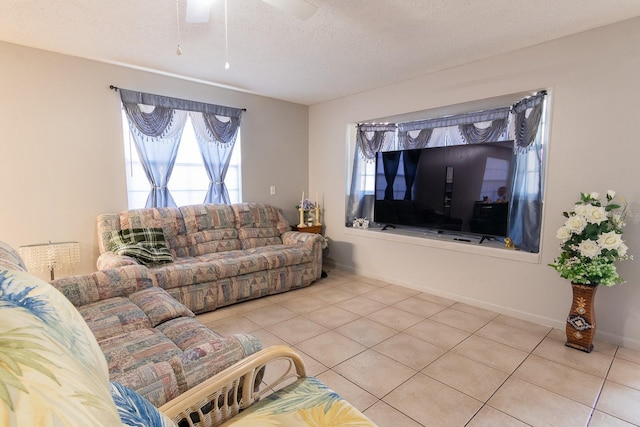 living room with tile patterned floors, baseboards, a textured ceiling, and ceiling fan