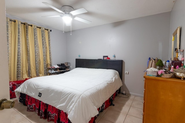 bedroom featuring light tile patterned flooring, a ceiling fan, and baseboards