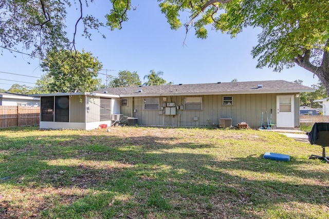 back of property with central AC, a yard, fence, and a sunroom